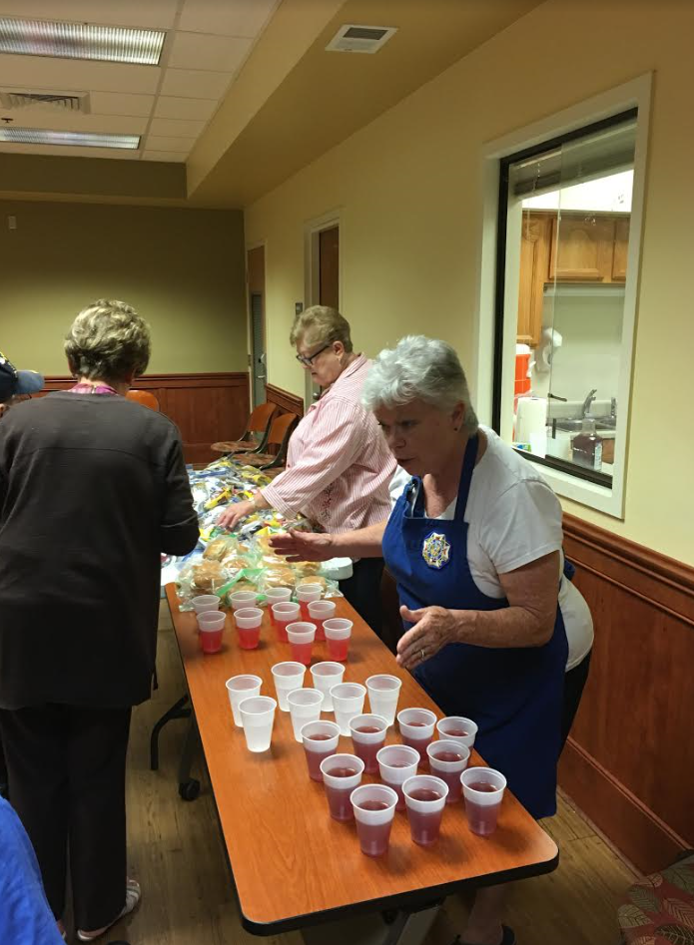 Auxiliary President Carolyn Hurd and Pam Koberg pass out refreshments at the bingo event.
